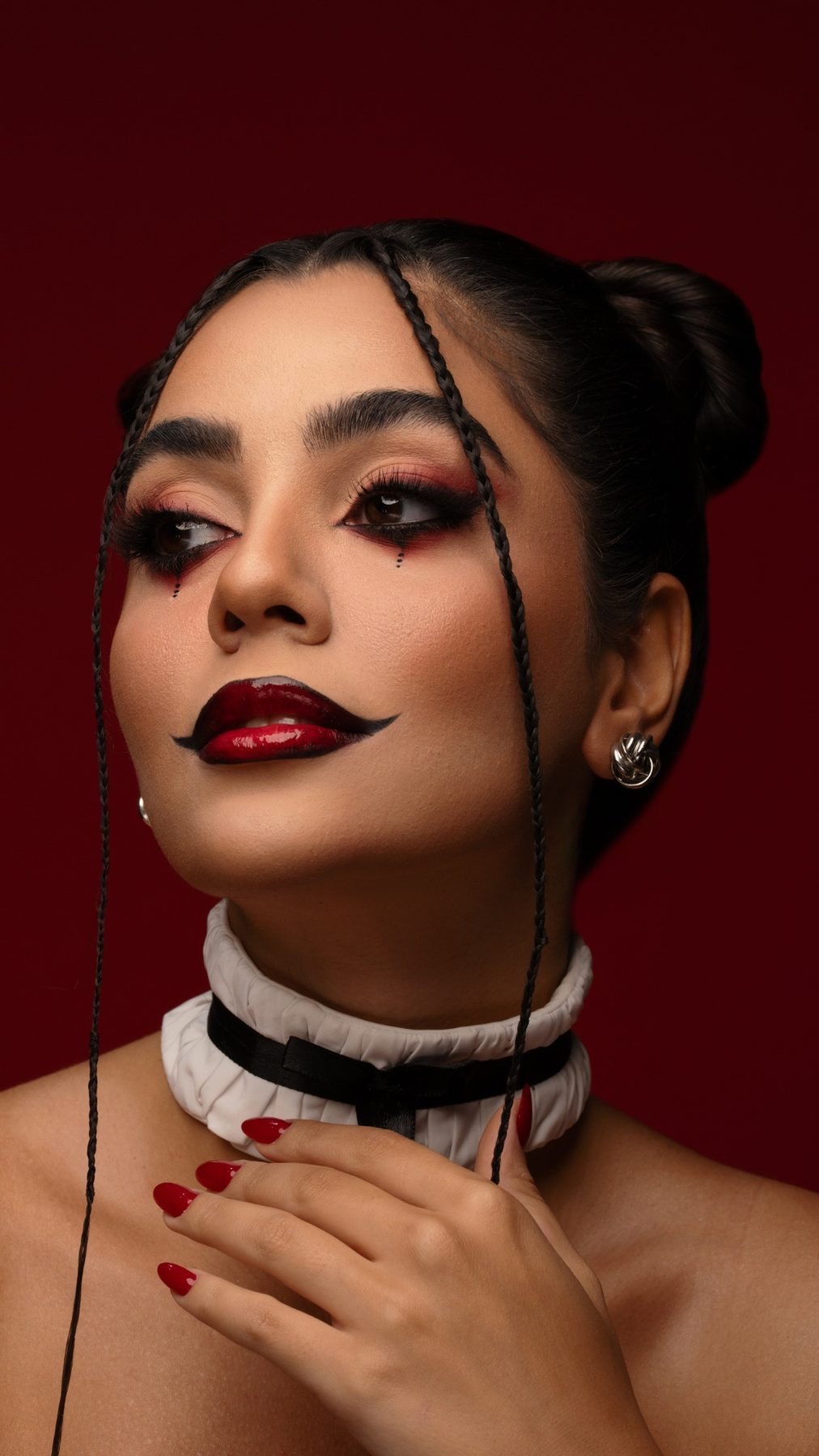 Red editorial beauty portrait with graphic makeup