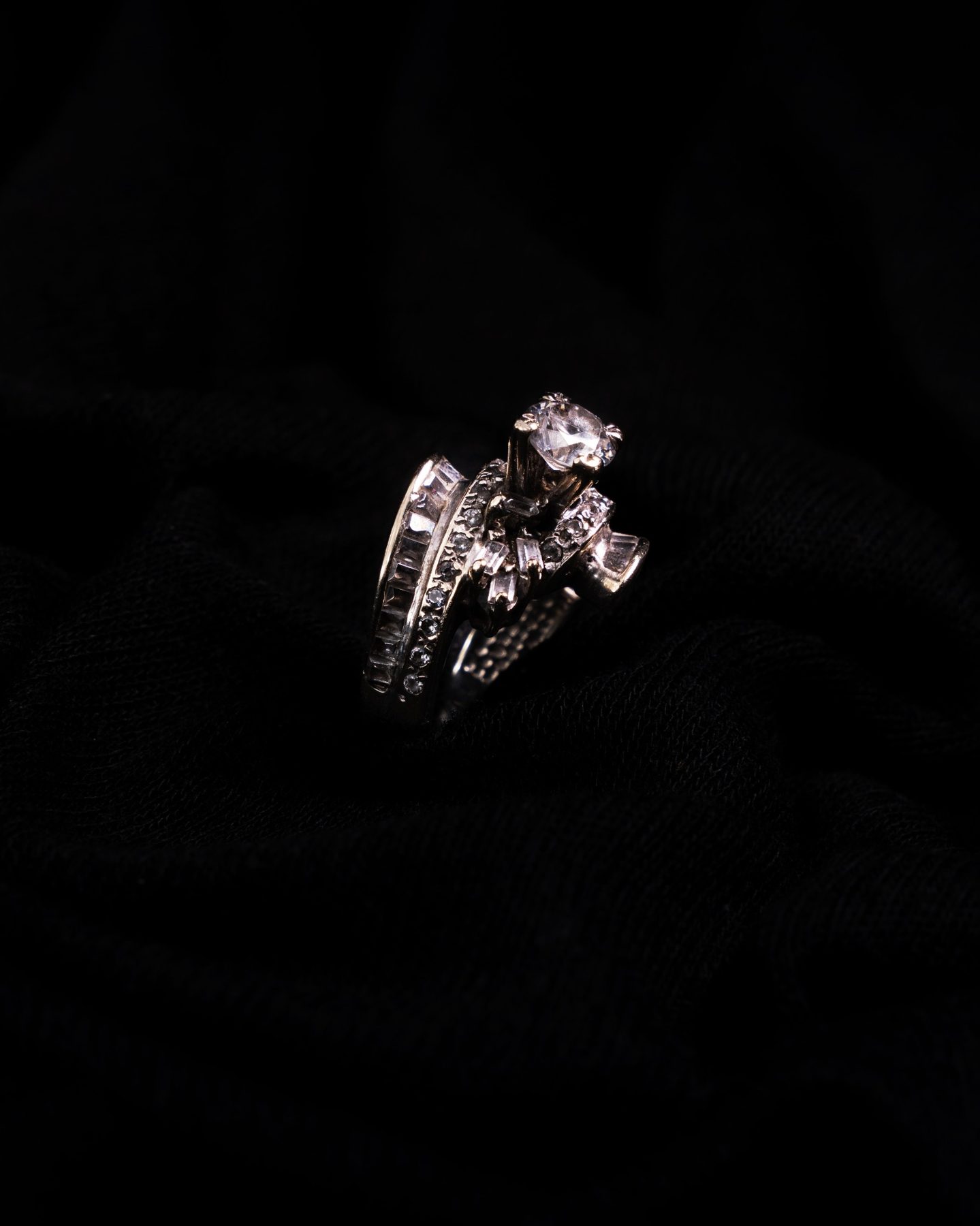 Silver ring photographed on black fabric